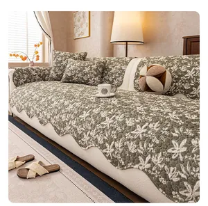 Detail der gesteppten olivgrünen Sofaauflage mit Blumenmuster und gewelltem Rand