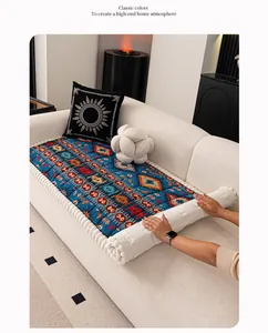 Detail view of American vintage sofa cushion with geometric patterns and white pom-pom fringe