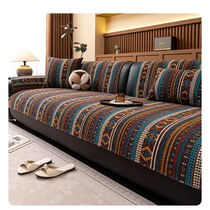 Detail of bohemian chenille sofa cover with ethnic stripes on black leather couch