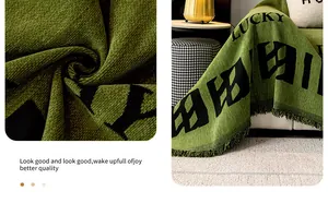 Détail du jeté en chenille verte avec lettrage lucky et bordures à franges main