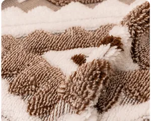 Close-up of soft brown and beige geometric sherpa fleece fabric with plush texture