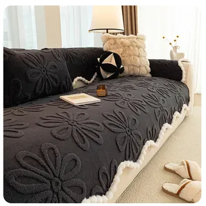 Close-up of dark grey plush sofa cover with 3D floral pattern and white pom-pom trim