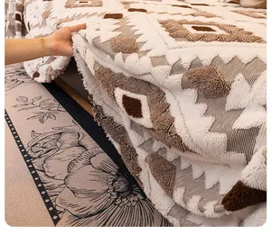 Detailed view of thick plush sofa blanket with geometric patterns and fringe edges