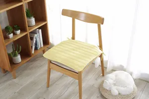 Detalle del cojín de algodón acolchado amarillo claro con lazos para fijar a la silla