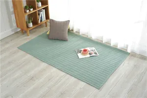 Detail of light green quilted cotton mat with diamond pattern on wooden floor