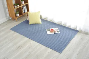Close-up of blue quilted cotton mat with diamond stitching on a light wooden floor