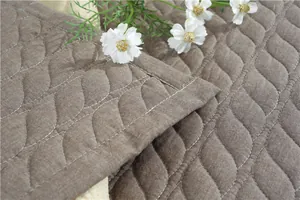 Detail showing wavy quilted cotton fabric and precision stitching of the soft floor mat