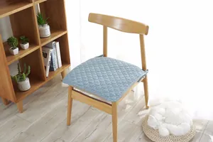 Detalle de cojín de silla azul claro acolchado con costuras de diamante y lazos de sujeción