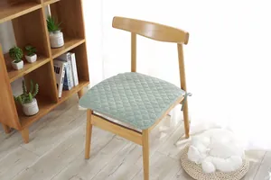 Primer plano del cojín de silla acolchado de algodón verde claro con cintas