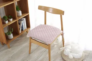 Detalle de cojín para silla acolchado rosa con lazos y textura de diamantes