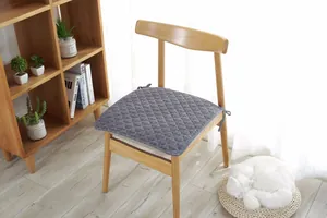 Primer plano del cojín de silla gris acolchado con textura de diamante y lazos