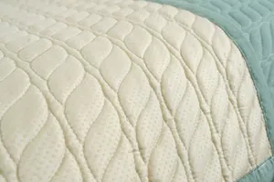 Detalle de la alfombra de algodón acolchado con costuras onduladas y textura de puntos