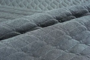 Detalle del cojín de silla en algodón gris oscuro con elegante acolchado de hojas y tacto suave