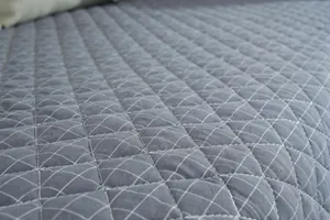 Primer plano del cojín de silla de algodón gris acolchado con finas costuras blancas