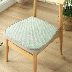 Close-up of a woven cotton plaid chair cushion with brown piping on a wooden seat