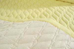 Detalle del cojín de silla en algodón liso con acolchado de hojas y base antideslizante