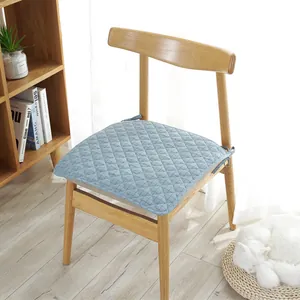 Nordic minimalist light blue quilted cotton chair pad with ties on a wooden chair