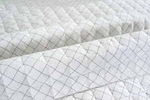 Primer plano de la textura acolchada de diamantes en el cojín de silla de algodón blanco