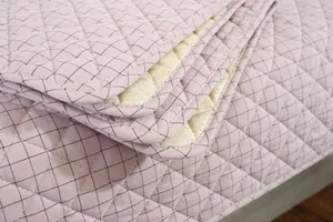 Close-up of quilted cotton chair pad showing purple plaid surface and anti-slip backing
