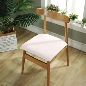 Coussin de chaise en peluche rose clair minimaliste sur une chaise en bois massif