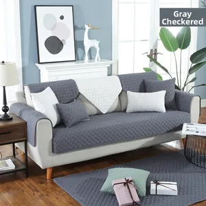 Detailed view of quilted grey checkered cotton sofa cover with anti-slip texture