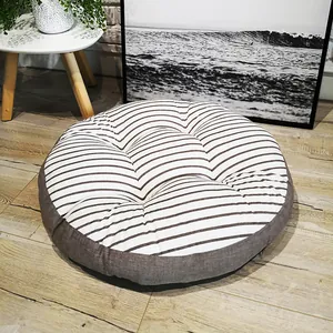 Macro shot of striped cotton linen floor cushion on light wood floor in home setting