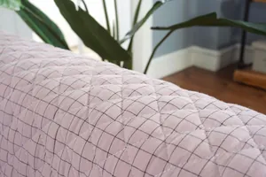 Detalle de cojín de asiento de algodón acolchado rosa con patrón de rejilla negra