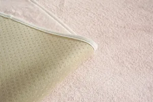 Détail macro du velours rose doux et de la base antidérapante à picots du coussin de chaise
