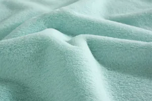 Vue macro du tissu en peluche vert menthe montrant la texture douce et les fibres denses