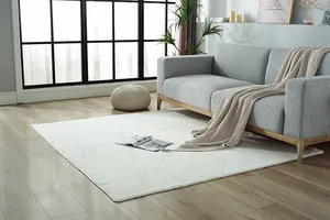 Detail of white faux rabbit fur sofa cover with geometric texture on wood floor