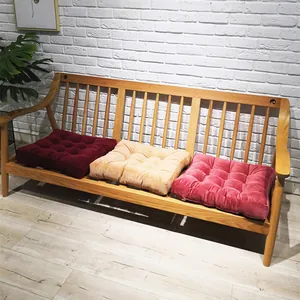 Detail of square tufted cushions with nine-point stitching in warm home setting