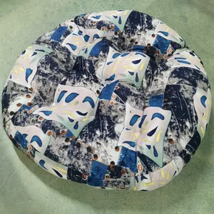 Macro detail of round patchwork seat cushion with blue floral and geometric patterns