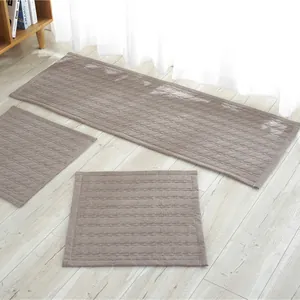 Juego de tres alfombrillas acolchadas antideslizantes gris pardo sobre suelo de madera
