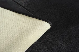 Détail du coussin de chaise en peluche noire avec envers antidérapant et bord cousu
