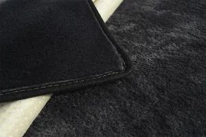 Détail d'un coussin en peluche avec dossier antidérapant et bordure noire cousue solide