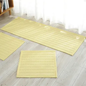 Detalle del juego de cojines de algodón amarillo claro con acolchado ondulado en suelo