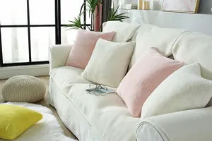 Detail of plush faux rabbit fur sofa cushions in beige and pink for winter comfort