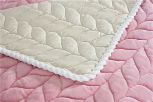 Detail of pink leaf-quilted plush fabric with white woven cord piping and velvet texture