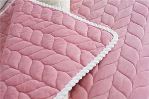 Detail of pink plush rug with quilted leaf texture and white twisted rope border edge