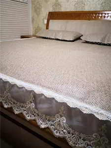 Detail of summer rattan mattress featuring elegant white lace embroidery and woven texture