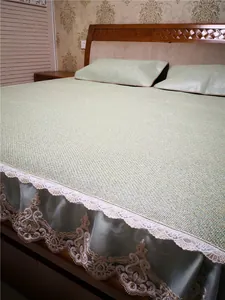 Detail of light green summer rattan mat with elegant white lace borders and floral embroidery