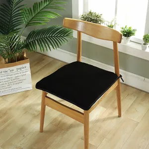 Détail d'un coussin de chaise en peluche noire avec des sangles de fixation solides