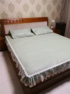Detailed view of light green rattan mattress pad with elegant beige lace and embroidery