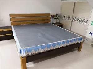 Detail of gray breathable rattan mattress with blue silk ruffles and white lace edging