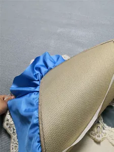 Detail of blue satin ruffle edge with golden flower embroidery lace on breathable mat