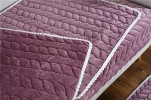 Detail of purple plush sofa cover featuring leaf quilted pattern and white rope edging
