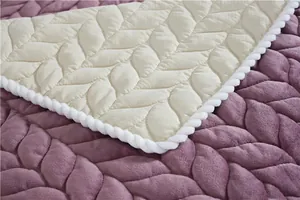 Detail of leaf-shaped quilted blanket showing purple velvet and beige woven textures