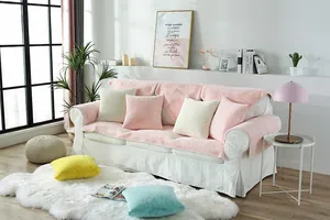 Close-up of pink faux rabbit fur sofa cover with colorful plush cushions in a cozy room