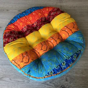 Close-up of a colorful round bohemian floor cushion with patchwork patterns on wood floor