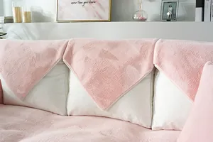 Close-up of thick pink faux rabbit fur sofa cover set with decorative triangle cushions